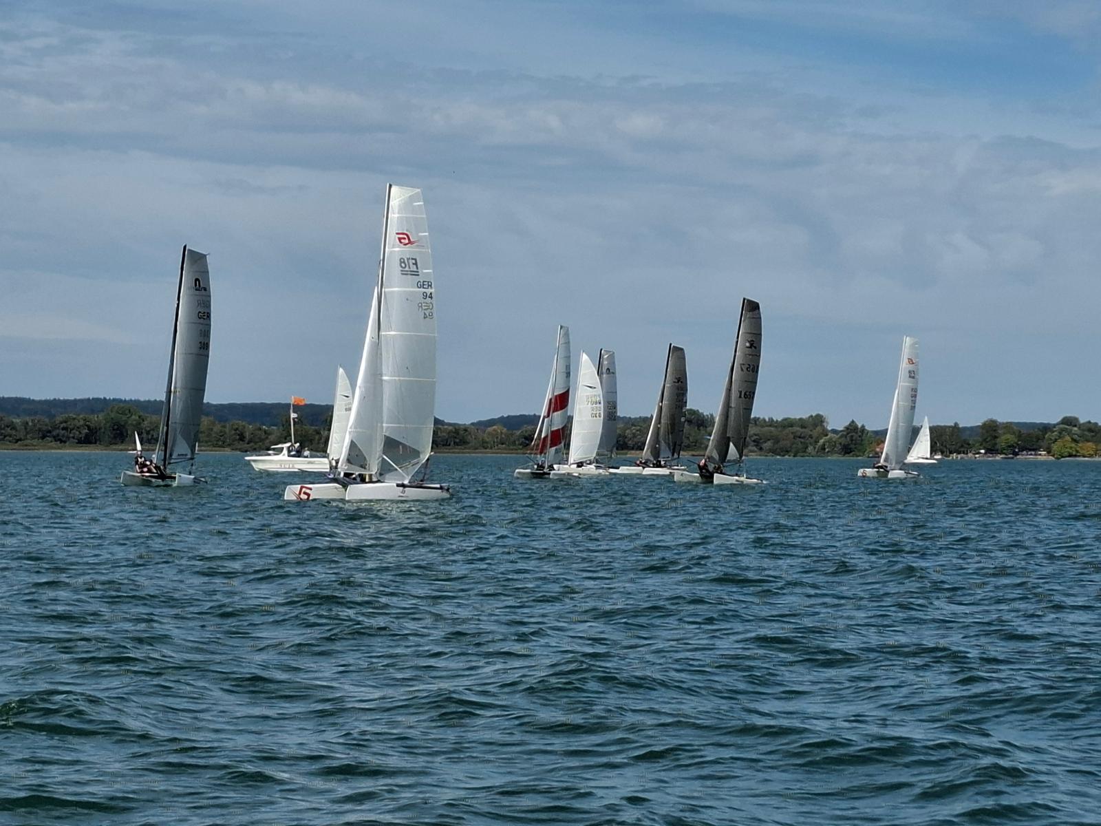 Formula-18-Flotte vor dem Start auf dem Ammersee, im Hintergrund das Startschiff